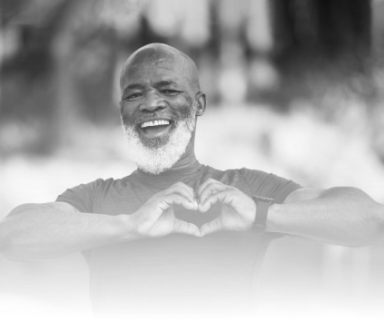 Smiling elderly man making heart gesture with hands